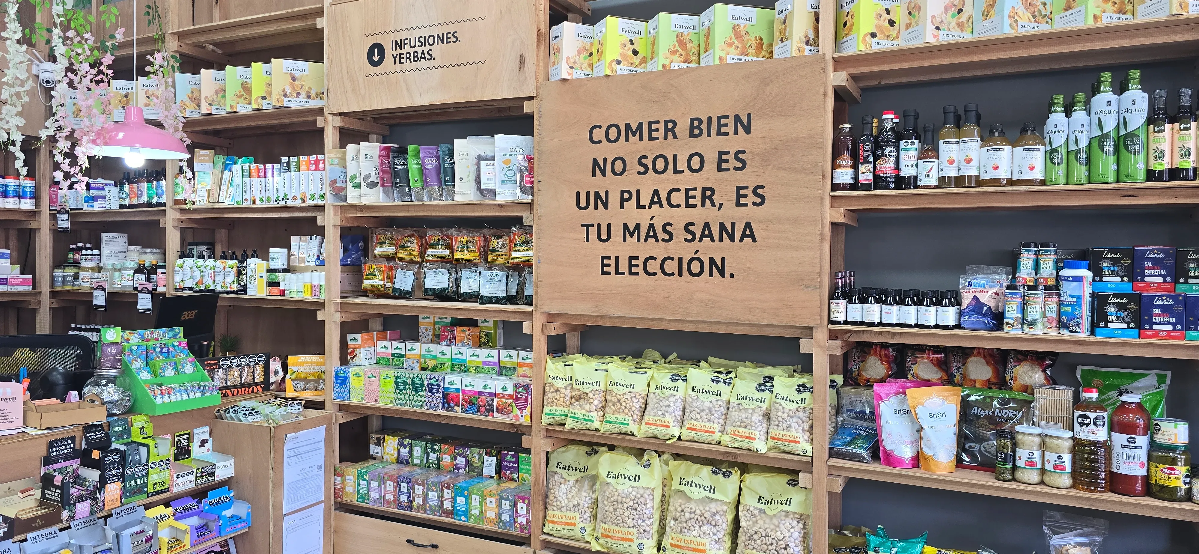 Interior de la Tienda Eatwell de Catamarca con el cartel de la marca y estantes de infusiones y almacén.